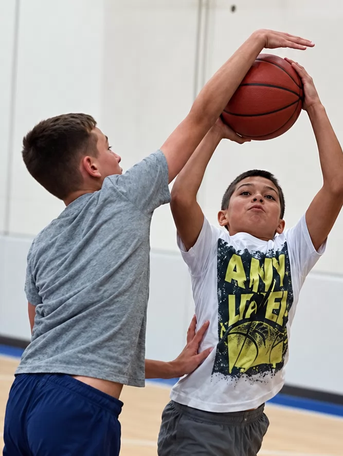 A player contesting a shot with arms raised.
